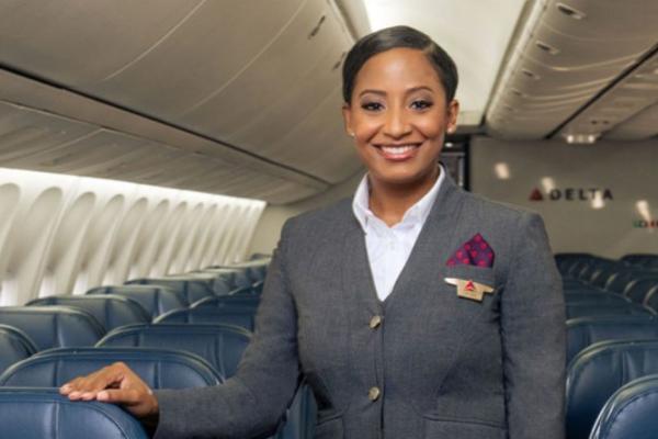 Delta flight attendant in grey uniform onboard aircraft