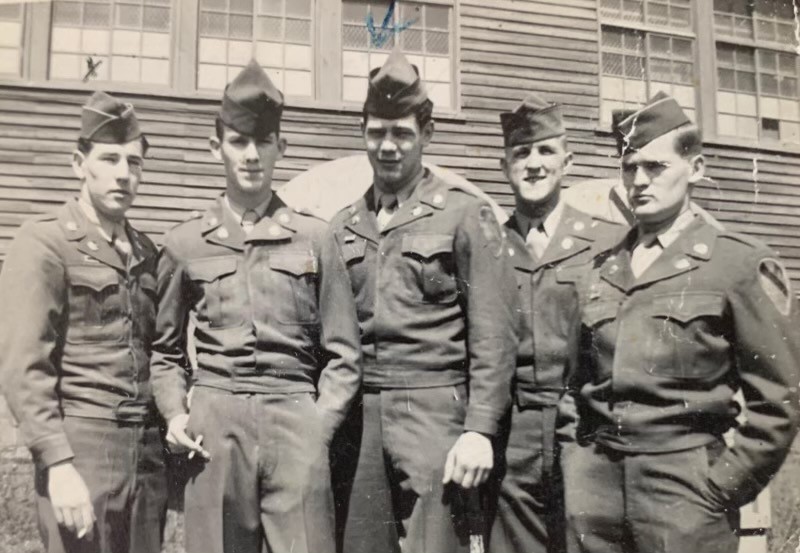 Reporting for duty, Johnnie (center) stands with fellow soldiers.