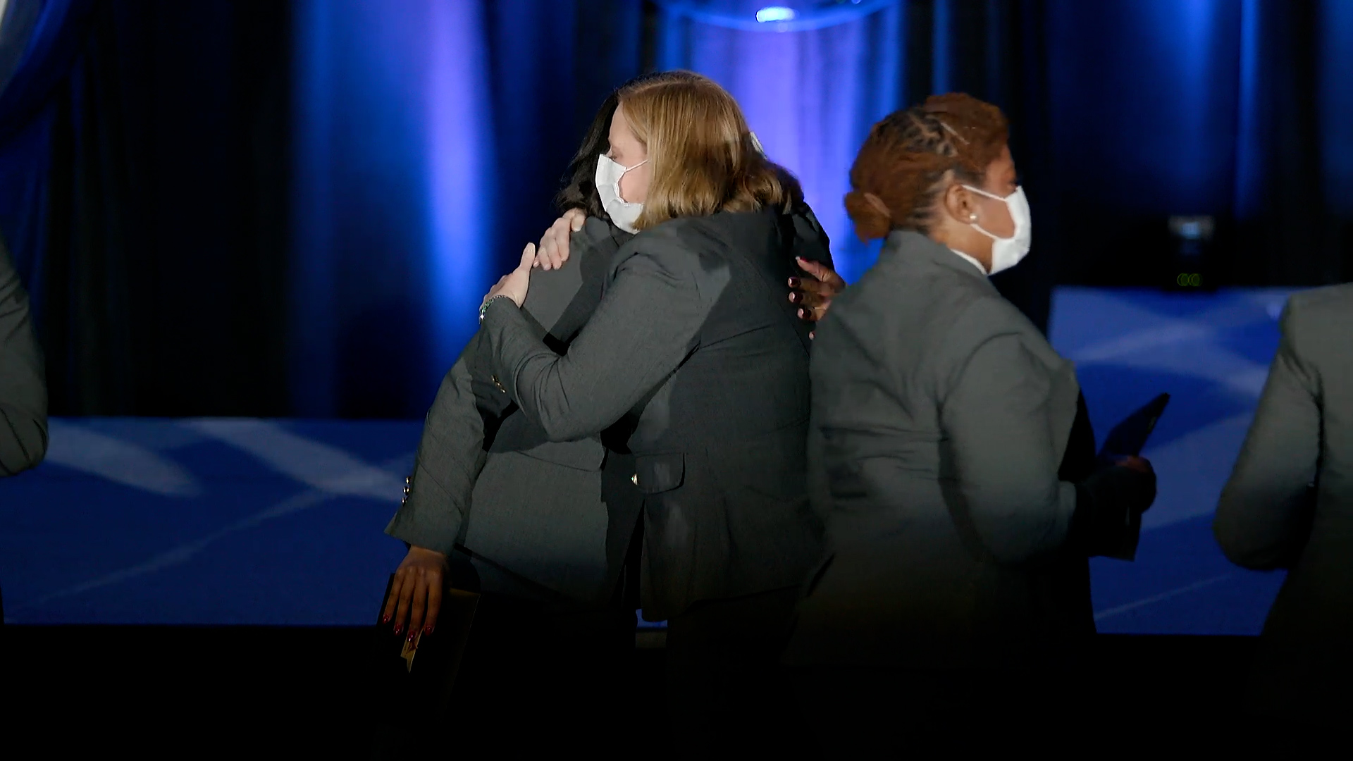 Flight attendants exchange hugs after graduation