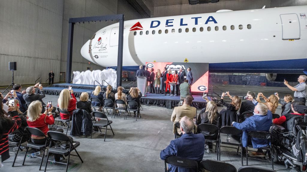 A curtain drops to reveal a memorial seal on a Delta Boeing 767-400 honoring renowned UGA football coach Vince Dooley.