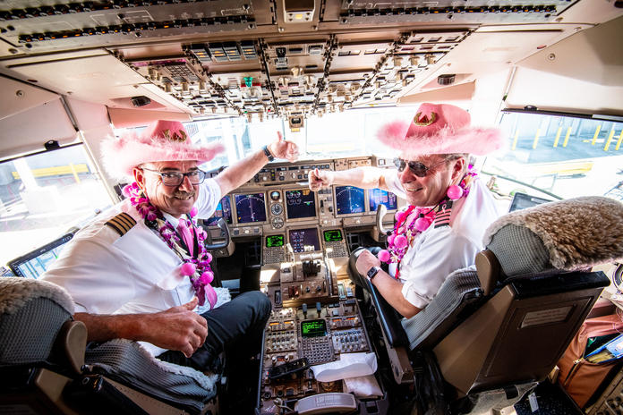 Two pilots sport all pink attire in the flight deck of the Breast Cancer One charter flight.
