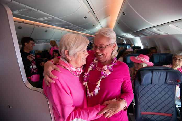 Two breast cancer survivors who joined Delta's Breast Cancer One charter flight hug.