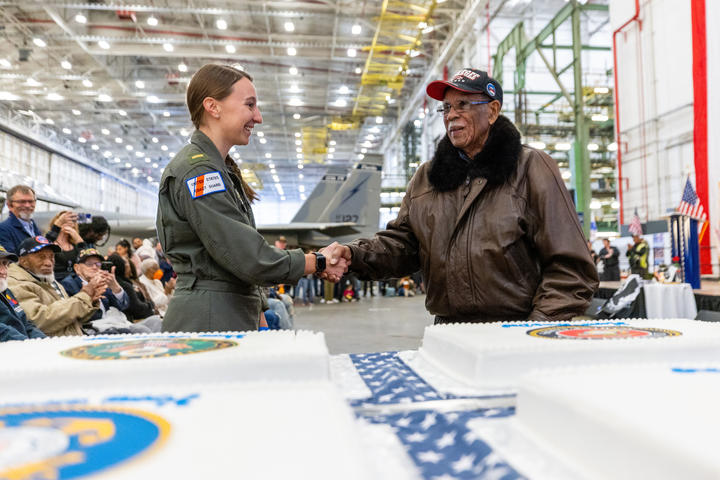 A member of the U.S. Coast Guard shakes hands with Daniel Keel, a U.S. Air Force veteran and Tuskegee Airman, at Delta's 12th annual Veterans Celebration.