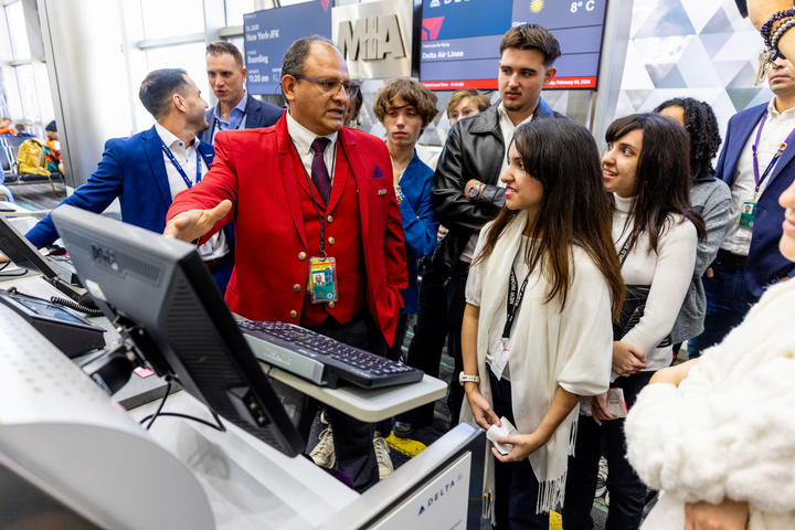 A Red Coat walks New Worl School of the Arts students through a "day in the life" at Miami International Airport as part of Delta and LATAM's Job Shadow Day.