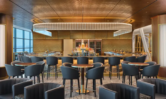 The premium bar at The Delta Lounge - JFK serves elevated takes on classic cocktails and features a standout Art Deco-inspired lighting fixture.