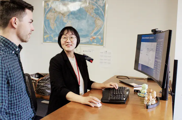 Jooyoung Kim, Director – International Network Planning, confers with a colleague.