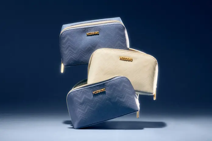 Three Delta x Missoni amenity kits are stacked on top of eachother.