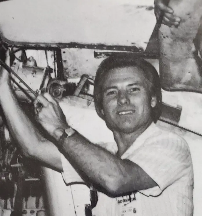 Black and white photo of Jimmy working on an airplane
