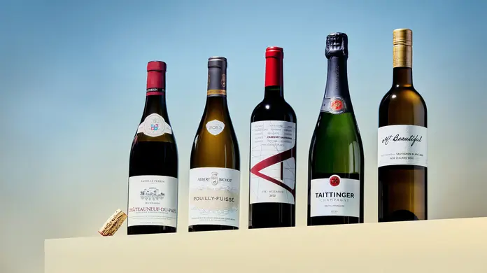 Various wine bottles lined up against a blue background.
