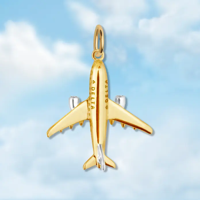 A gold airplane charm with silver accents.