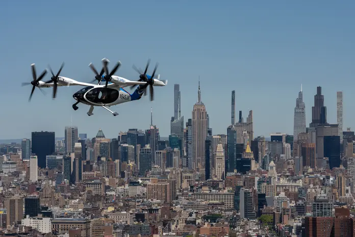 Joby electric air taxi flying above midtown Manhattan with the city skyline below.
