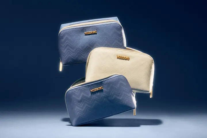 Three Delta x Missoni amenity kits are stacked on top of eachother.