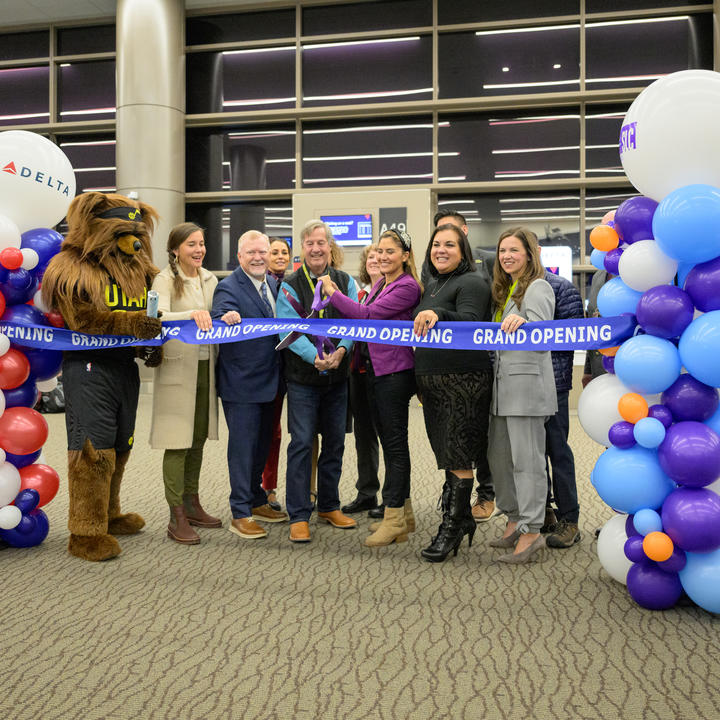A group cuts a ribbon to mark Delta's complete of the Concourse A expansion at Salt Lake City International Airport.