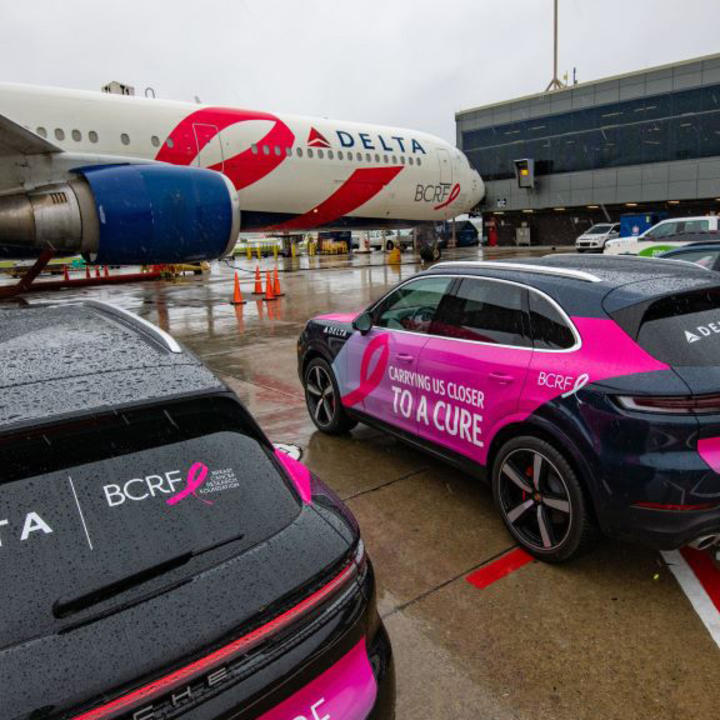 BCRF plane awaits takeoff amidst BCRF branded Porsches on September 26, 2024.