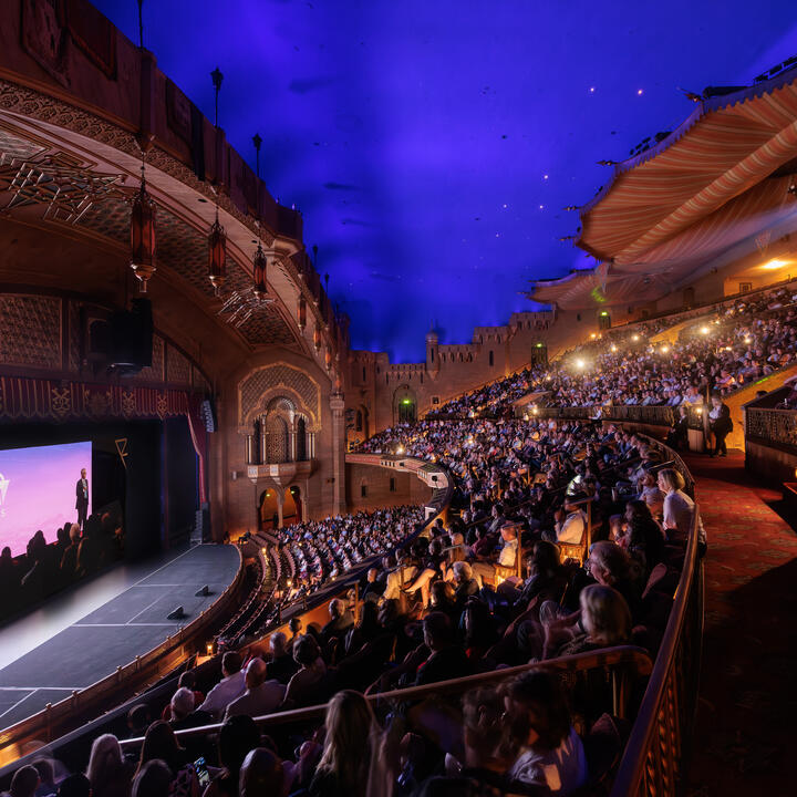 Interior view of the Fox Theatre, with guests seated and watching the film during the premiere event.
