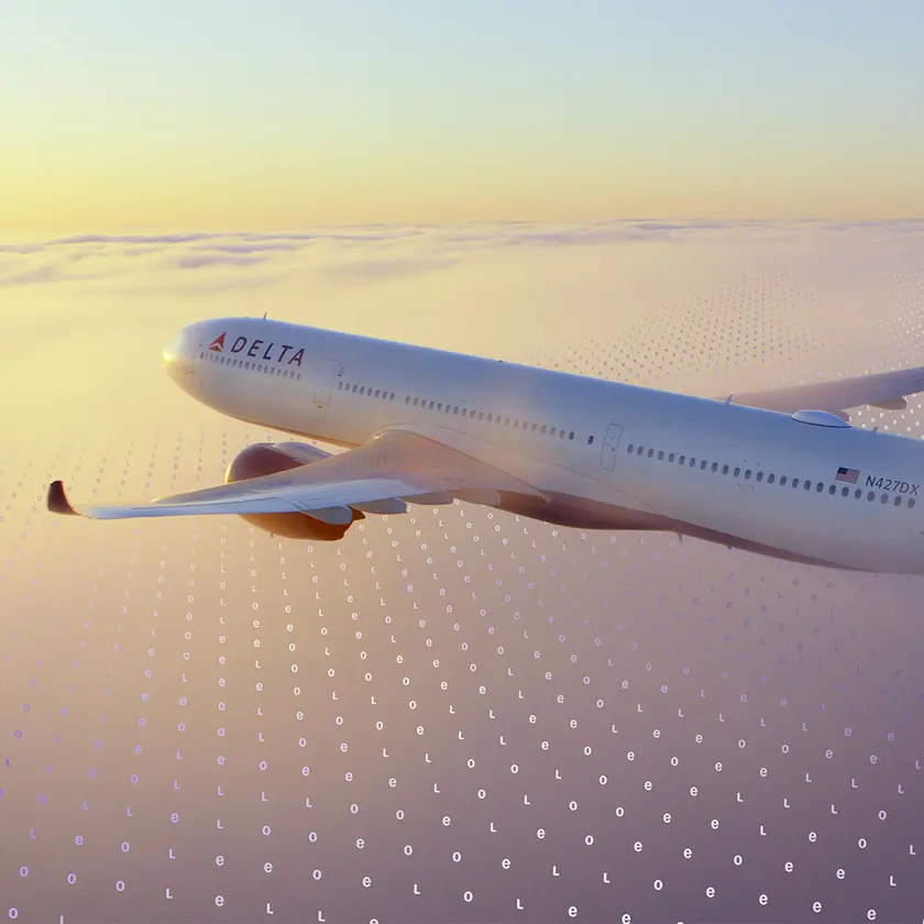 A Delta jet flies above a cloud layer at sunset, with a faint digital grid pattern overlaid across the sky.