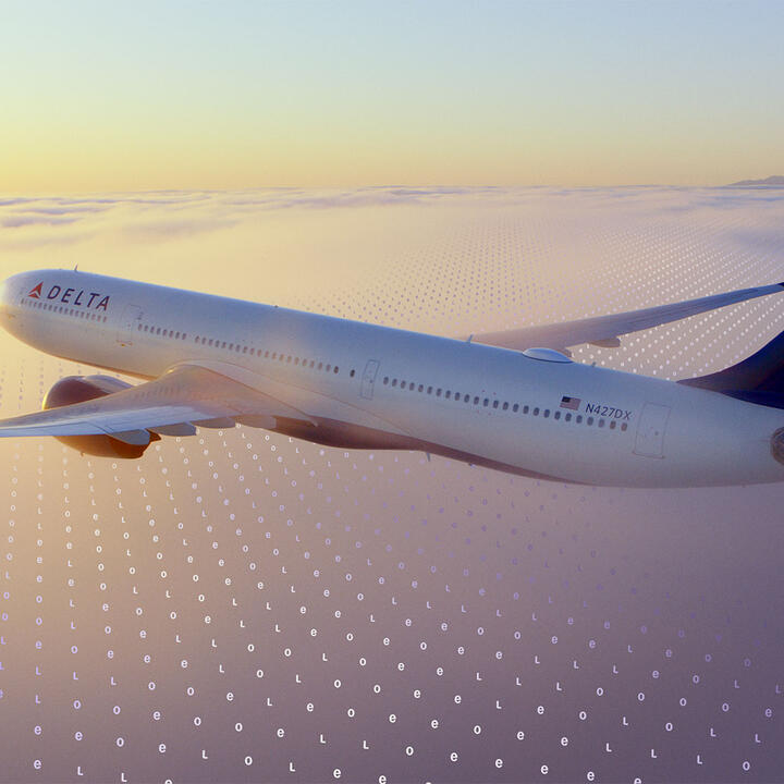 A Delta jet flies above a cloud layer at sunset, with a faint digital grid pattern overlaid across the sky.