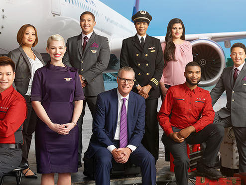 Ed, posing with Delta crew, in front of a large plane.