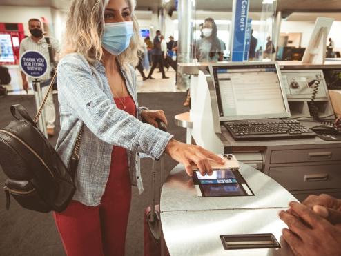 A woman uses an electronic boarding pass on the Fly Delta app.