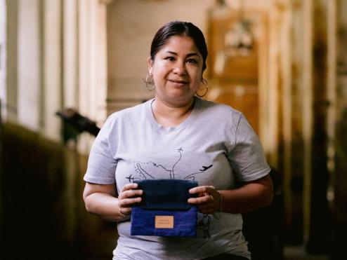 A Someone Somewhere artisan holding a Delta One amenity kit.