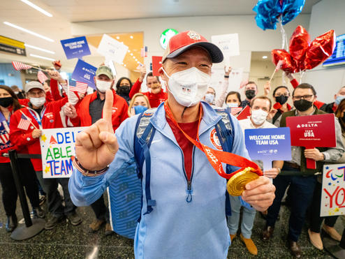 Jen Lee shows his gold medal after returning from the Paralympic Games.