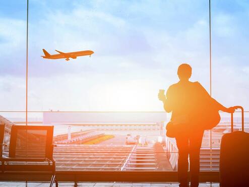 Customer watches plane at sunset