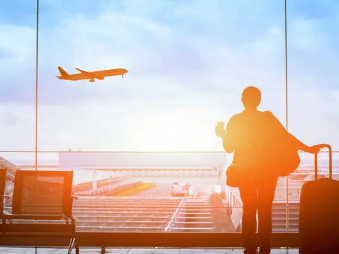 Customer watches plane at sunset