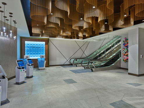 Once checked in, guests will ascend the monumental staircase or escalators, passing beneath dazzling ceiling fixtures modeled after ocean waves before arriving at the custom wood-screened area that marks the Club’s entrance. 