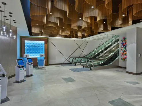 Once checked in, guests will ascend the monumental staircase or escalators, passing beneath dazzling ceiling fixtures modeled after ocean waves before arriving at the custom wood-screened area that marks the Club’s entrance. 
