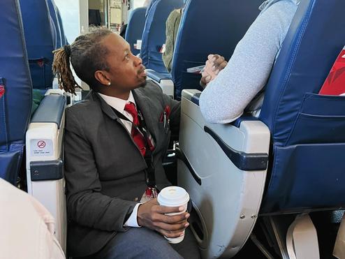 Endeavor Air flight attendant Floyd Dean-Shannon comforts a nervous customer during a Delta Connection flight from Charlotte to New York.