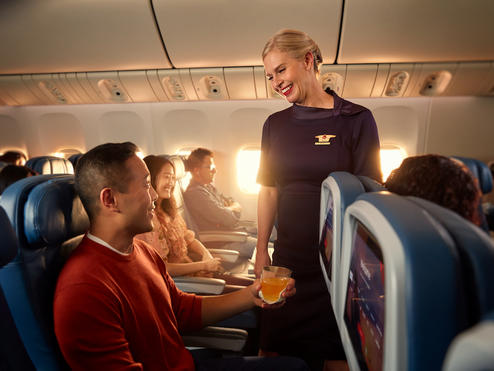 A Delta flight attendant helps a customer on board their flight.