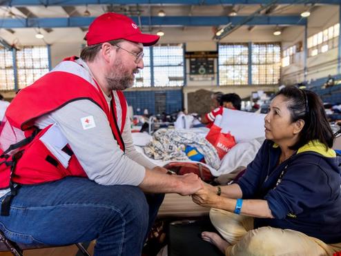 American Red Cross staffer Doyle Rader holds hands with Thao Tran