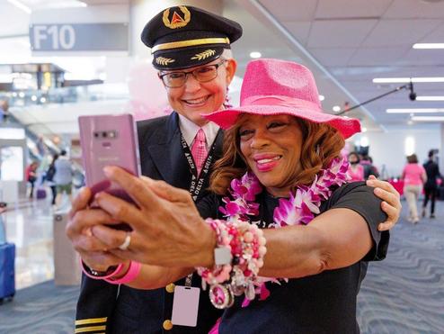 Delta employees pose for a photo before boarding Delta's Breast Cancer One charter