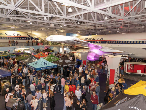 People attend the Hops in the Hangar event in the Delta Flight Museum.