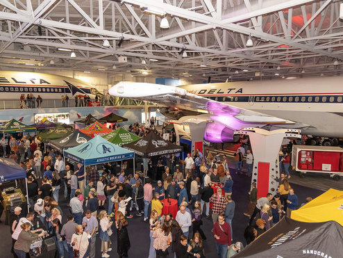 People attend the Hops in the Hangar event in the Delta Flight Museum.