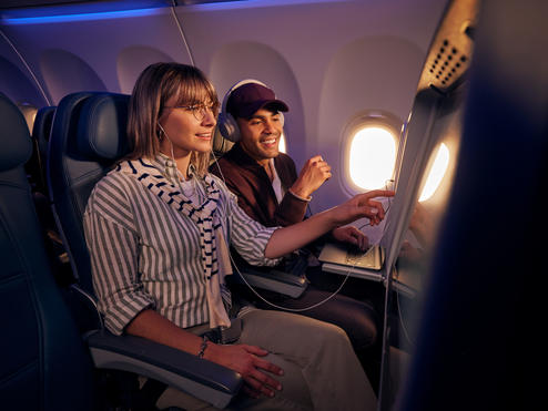 Customers browse seatback entertainment on a Delta flight.