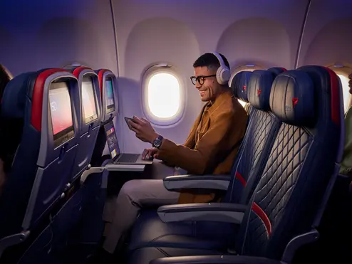 A customer uses Delta's fast, free Wi-Fi on board on their smart phone and laptop.