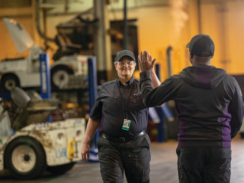 Delta employees high-five at work.