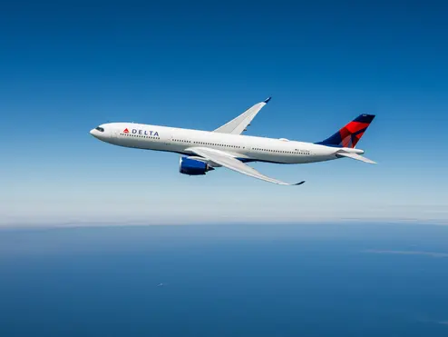 An Airbus A330-900neo in flight against a blue sky