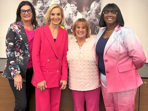EVP and Chief People Officer Allison Ausband posing with three Delta employee breast cancer survivors.