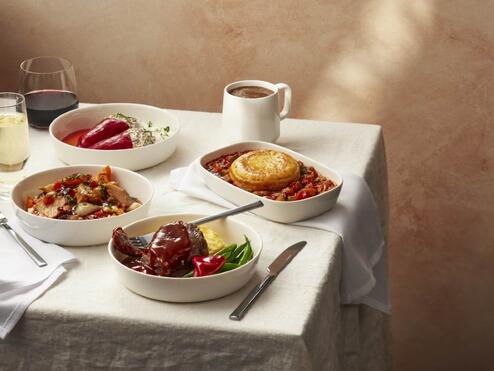 Various plated meals displayed on a table with a white tablecloth.