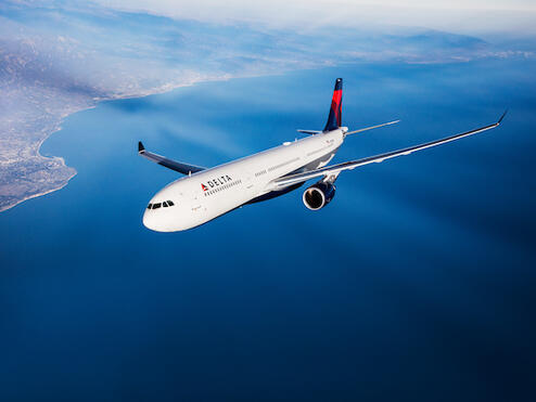 A Delta branded A330 flies in the sky. 