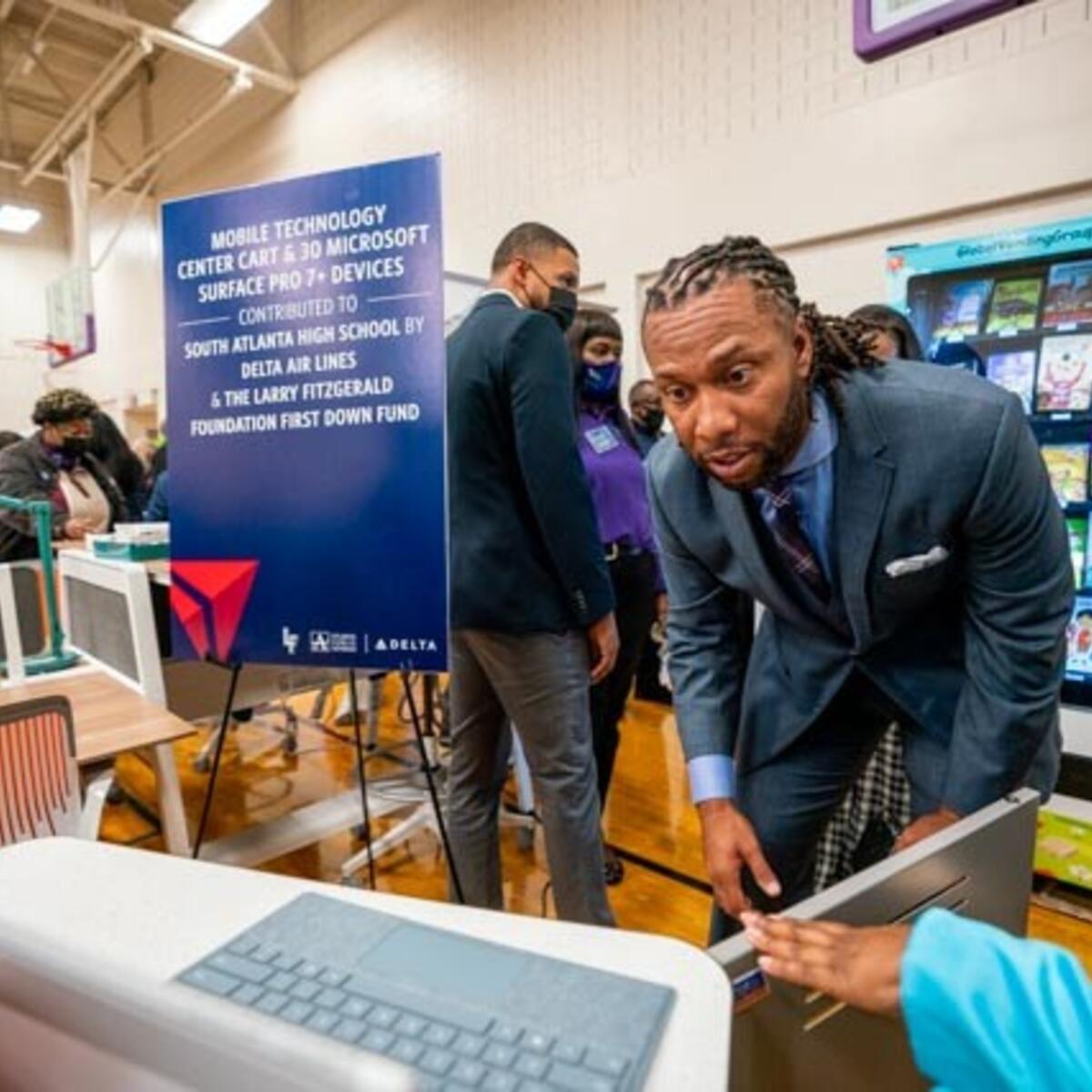 Larry Fitzgerald checks out one of the tablets presented to South Atlanta High School.