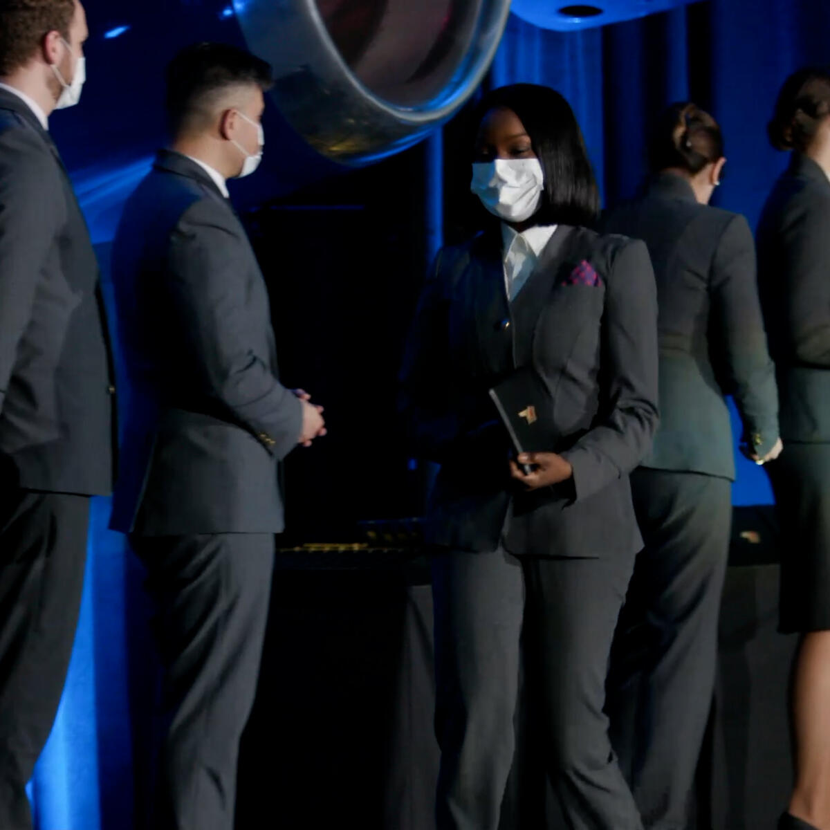 A Delta flight attendant walks off the stage with her new wings.