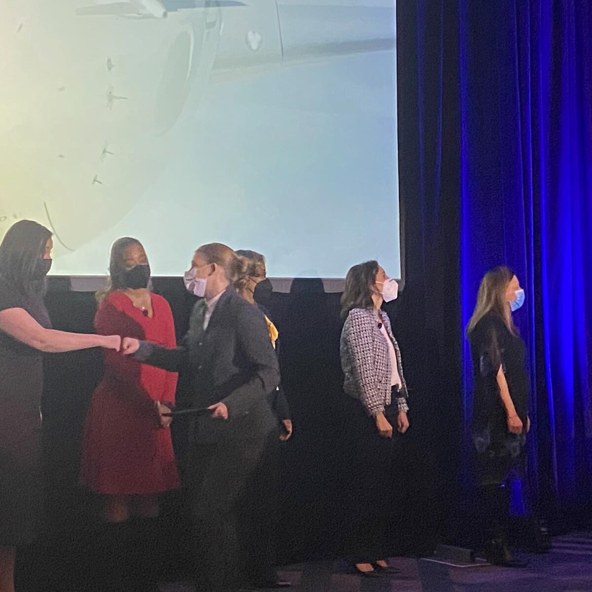 A flight attendant exchanges a fist bump after receiving her Delta wings.