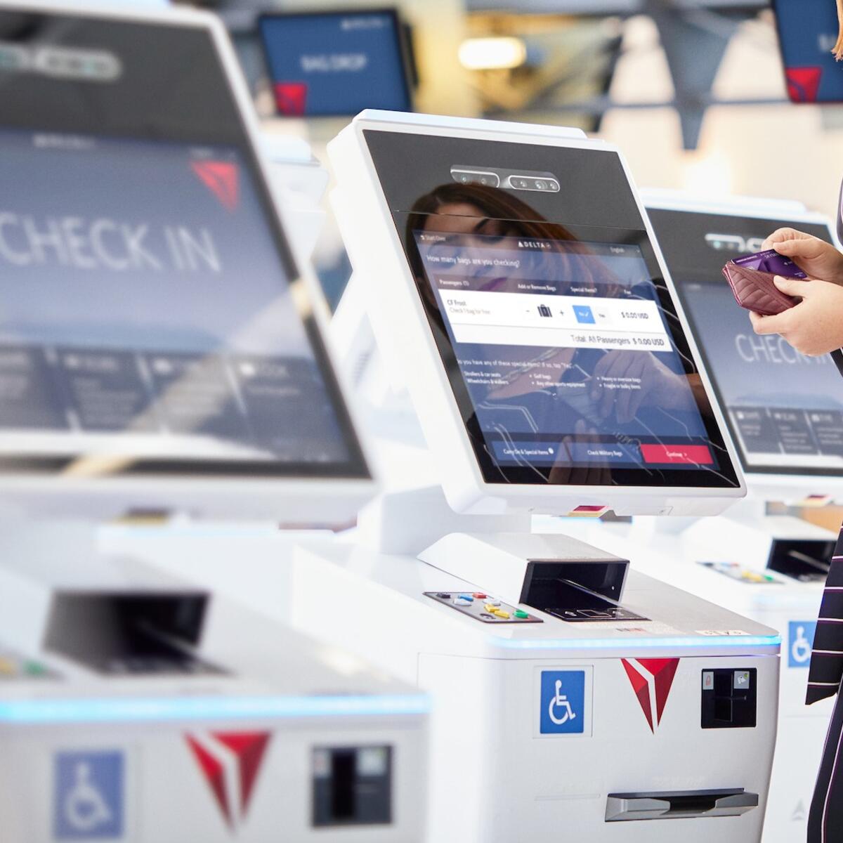 Customer checking in at a kiosk using their American Express card.