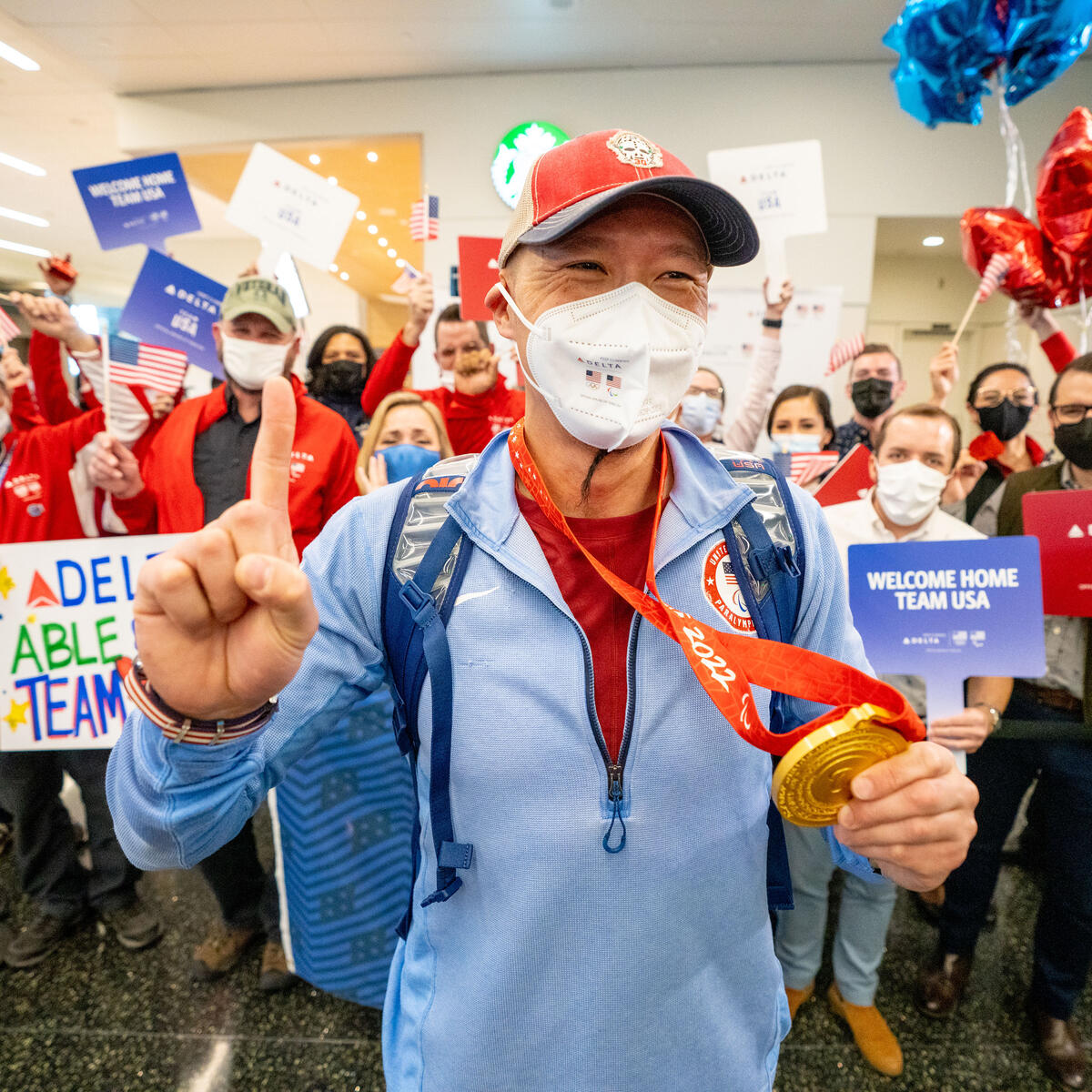 Jen Lee shows his gold medal after returning from the Paralympic Games.