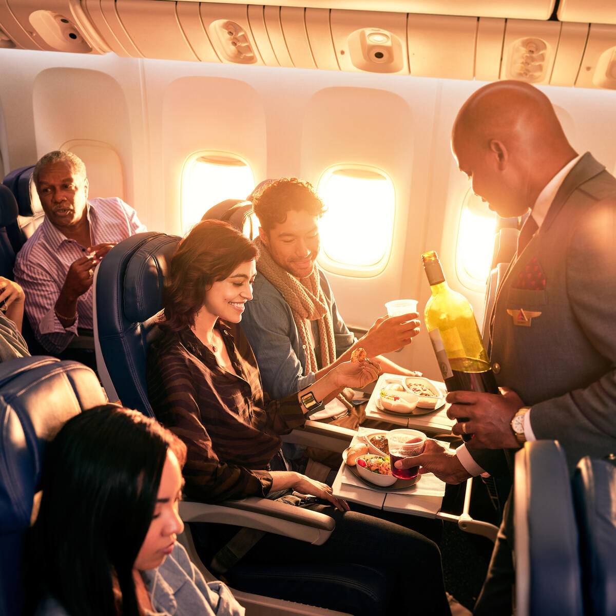 Delta flight attendant with Main Cabin customers.