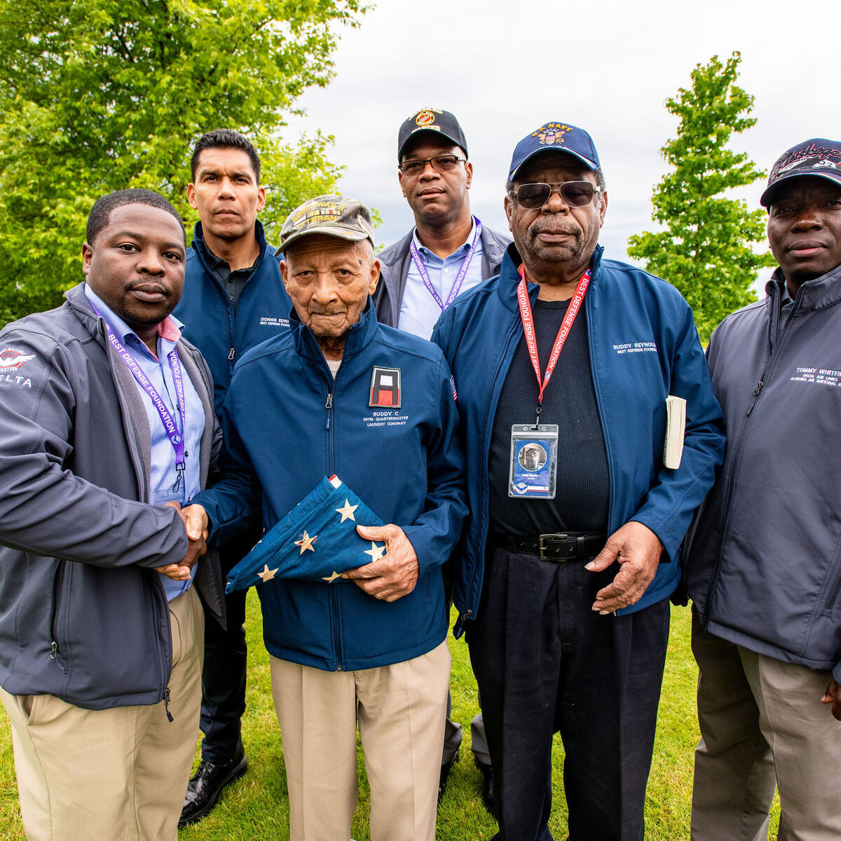 Delta’s Mikail Barnes, Pat Mills and Tommy Whitfield with Donnie Edwards, Buddy Reynolds and Buddy Reynolds Jr. at Brittany American Cemetery. 