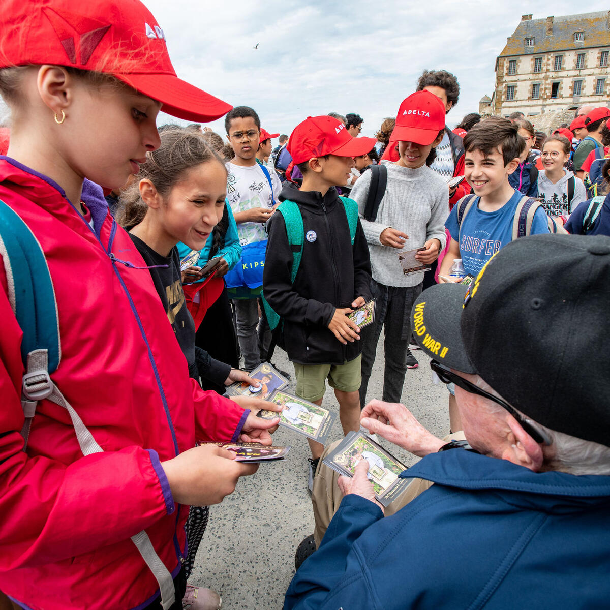 Raymond Dawkins passes his cards out to children at Mont St. Michel.